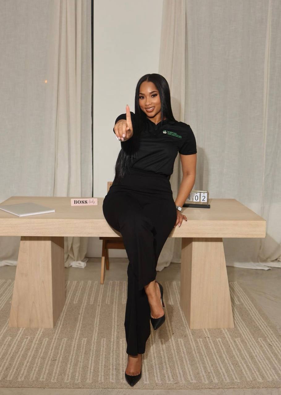 A smiling Fortune Tax Advisors strategist sitting on her desk and pointing toward the camera