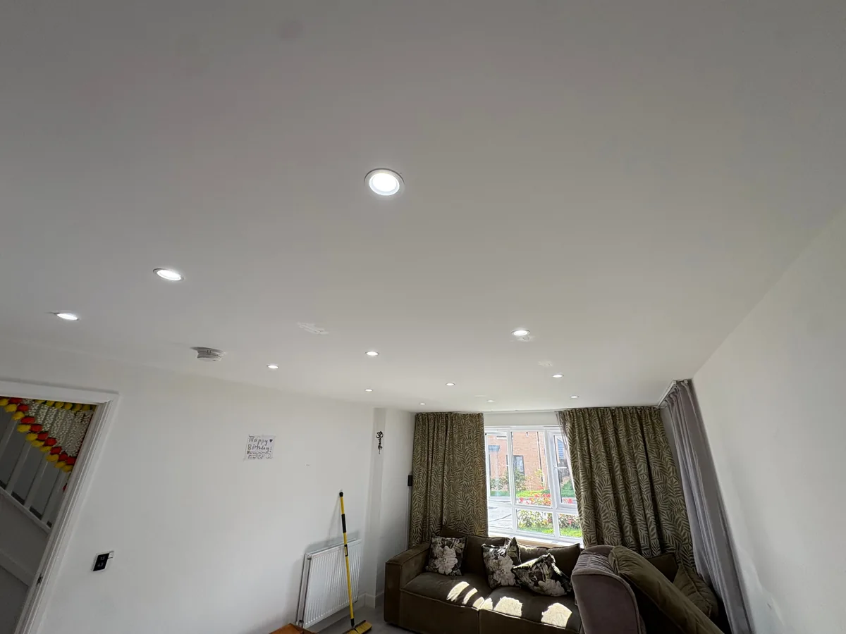 Recessed ceiling downlights switched on in a living room