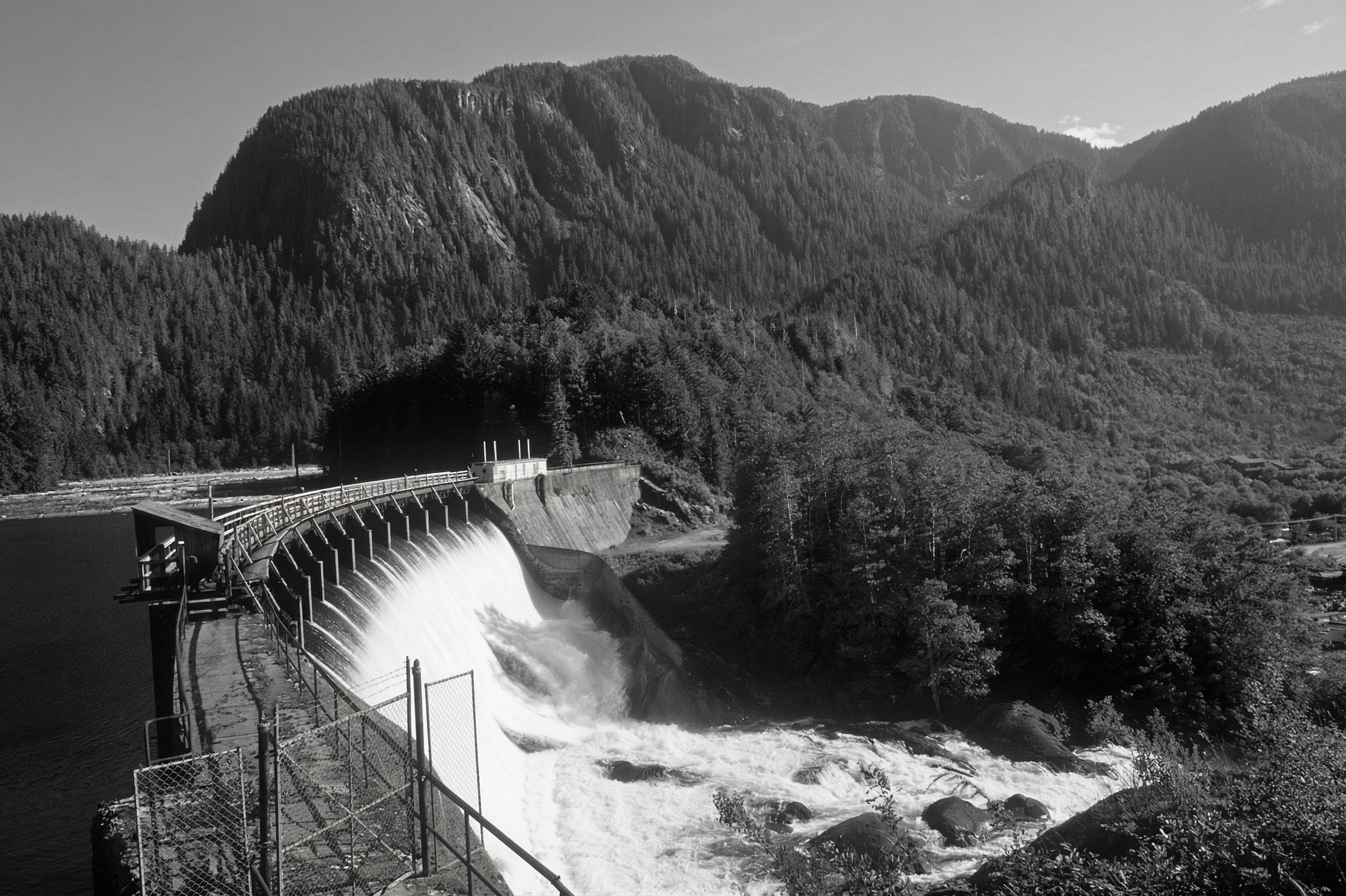 Hydroelectric dam infrastructure in a rugged coastal mountain landscape