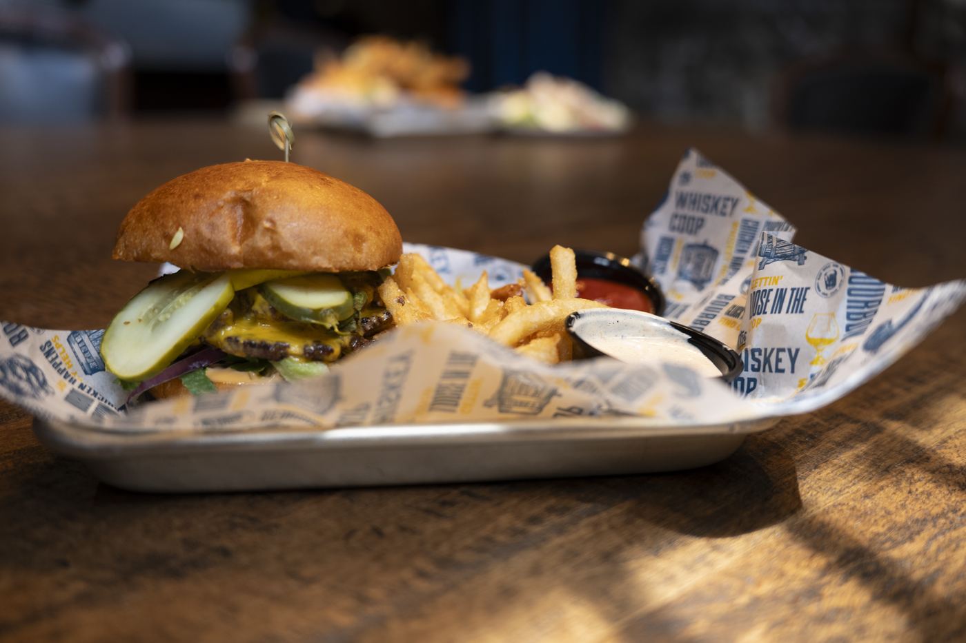 Signature burger and fries plated on branded paper