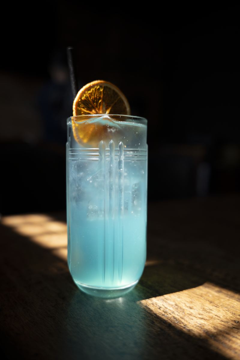 A blue highball in window light
