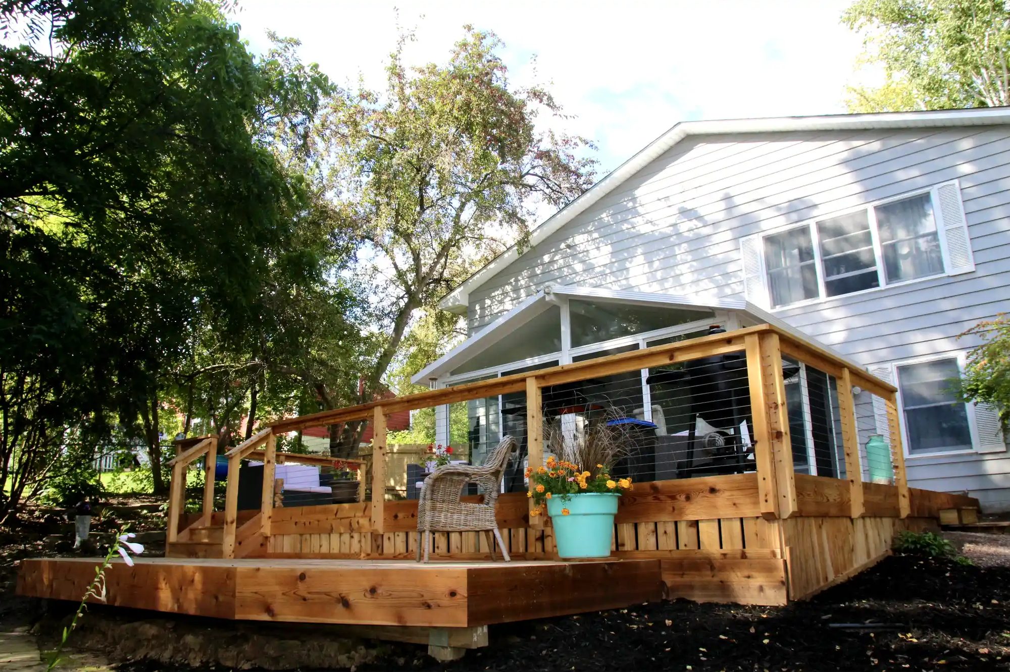 New cedar deck with cable railing and covered porch built by Charter Home Renovation