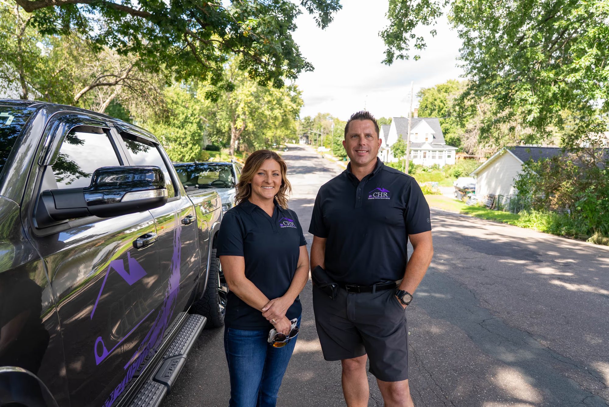 Charter Home Renovation owners standing beside their branded company truck