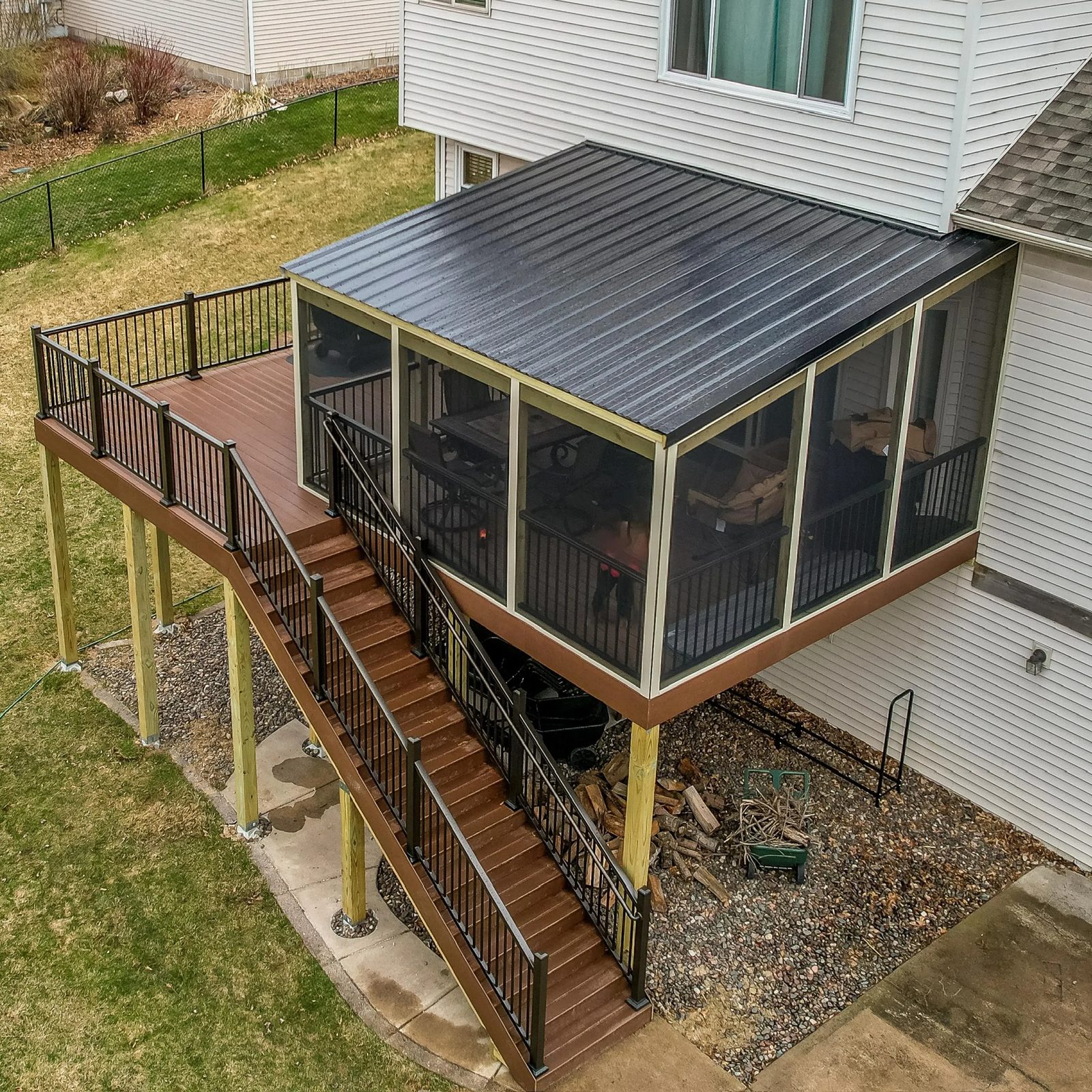 Elevated composite deck with screened porch and black railing