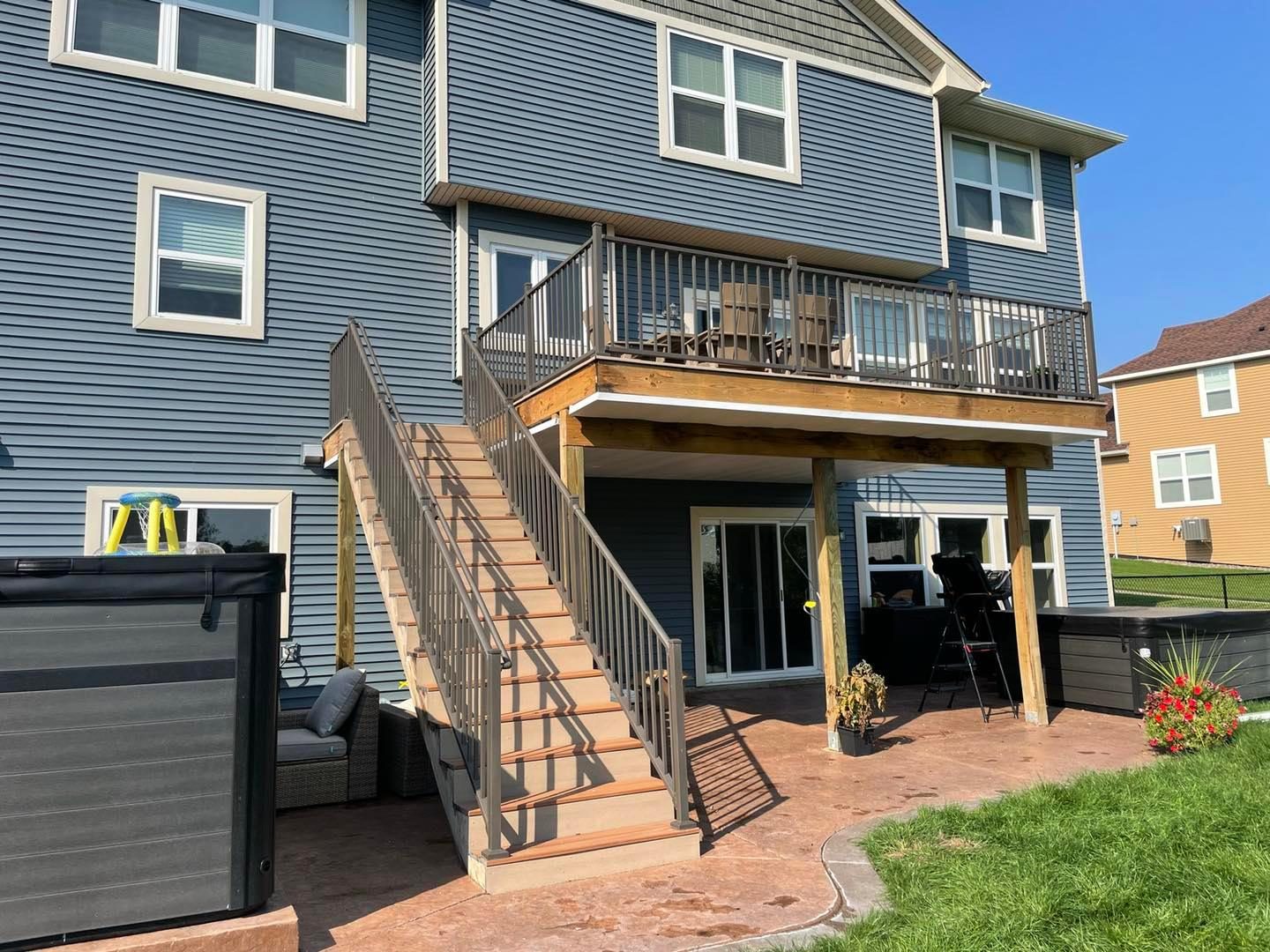 Second-story deck with stairs on a blue-sided home