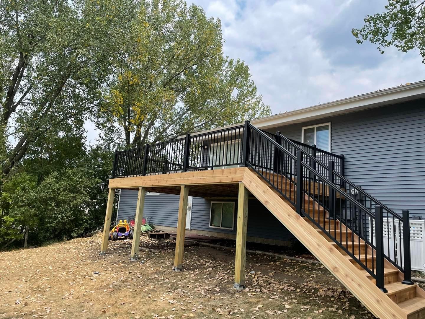 Elevated deck with black railing and long staircase
