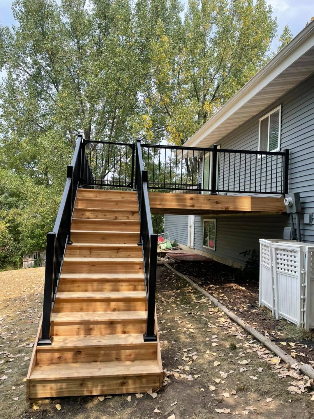 Cedar deck staircase with black railing