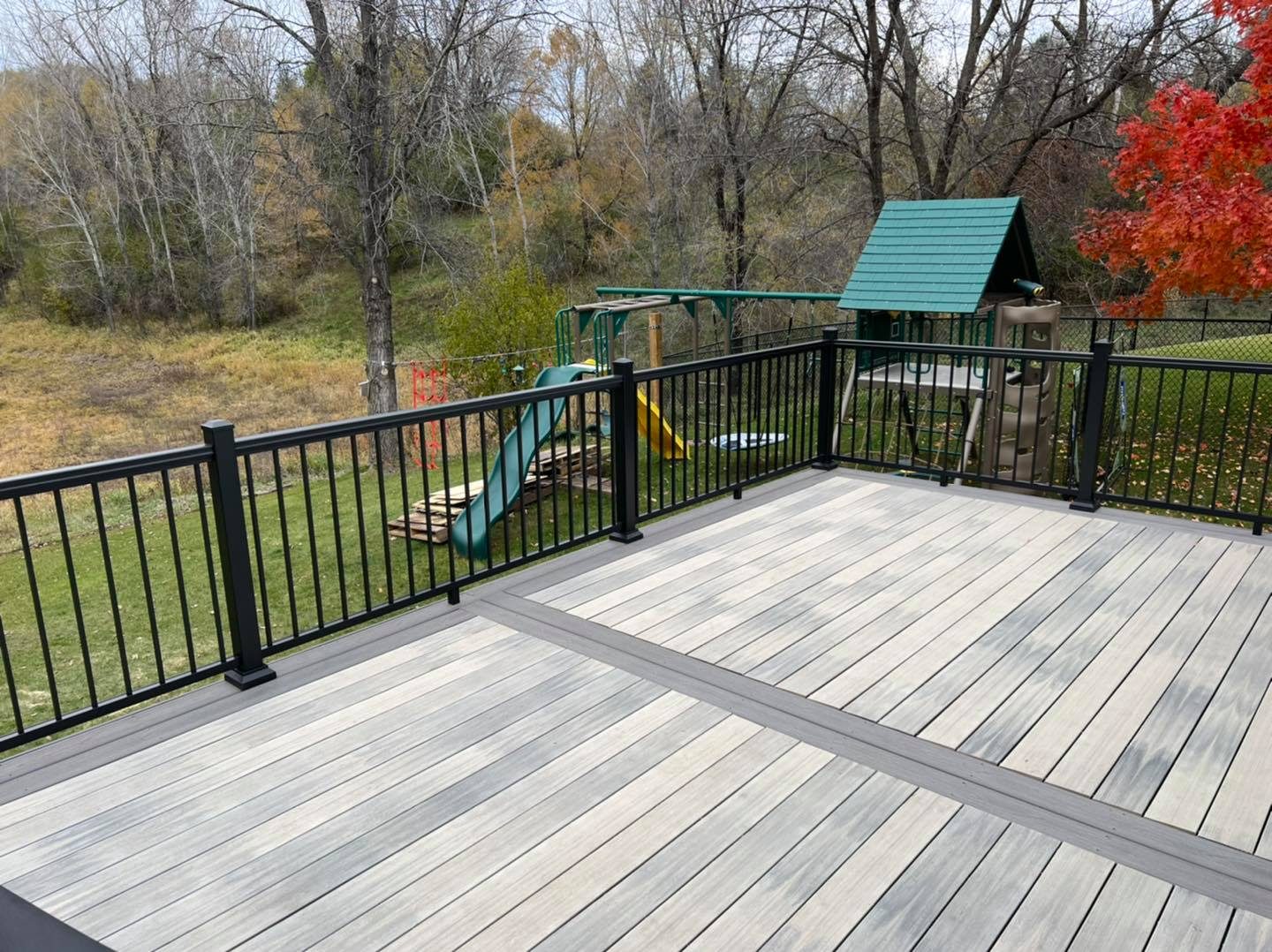 Composite deck with black railing overlooking the backyard