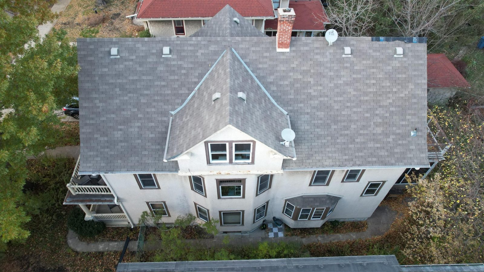 Finished gray shingle roof on a white stucco home