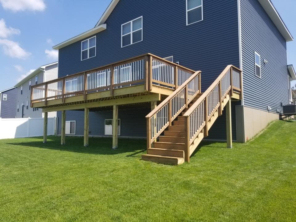 Two-story wood deck with stairs on a navy-sided home