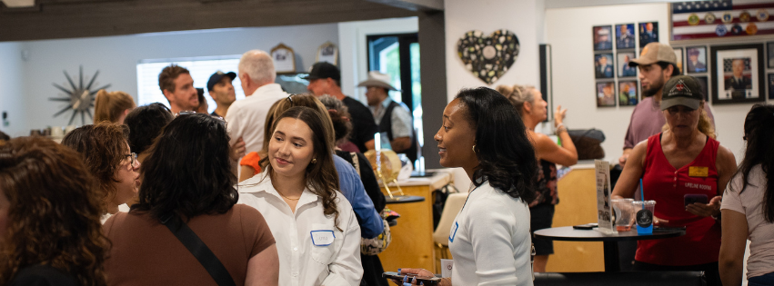 Guests talking and mingling at a Power Hour Happy Hour networking event in The Woodlands, Texas