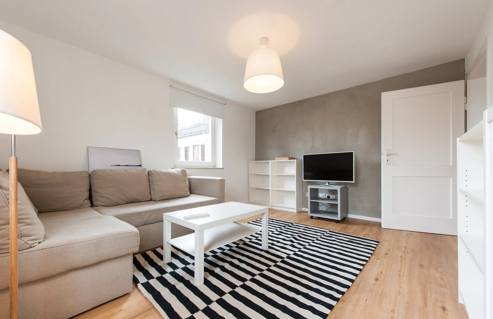Wohnzimmer mit Fernseher und Schlafsofa