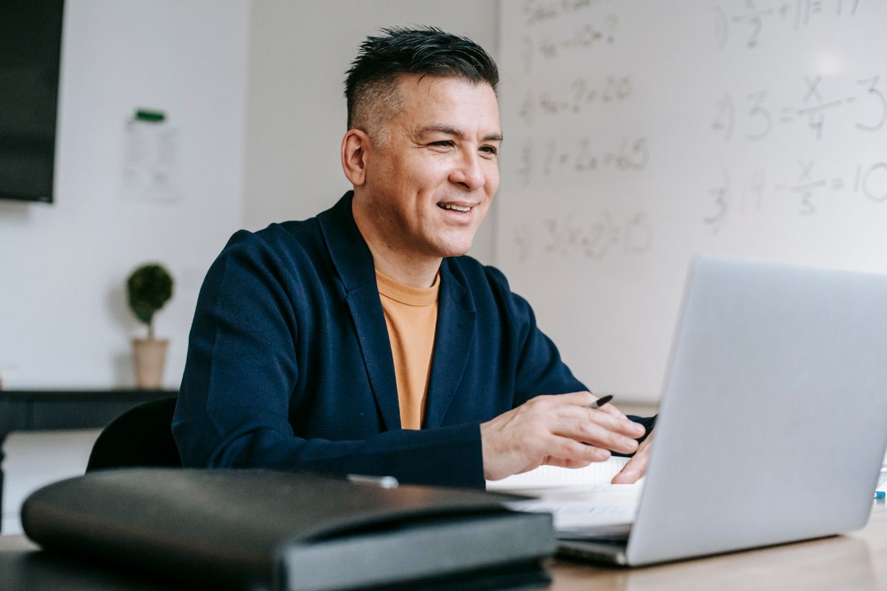 A smiling customer using a laptop in a bright workspace