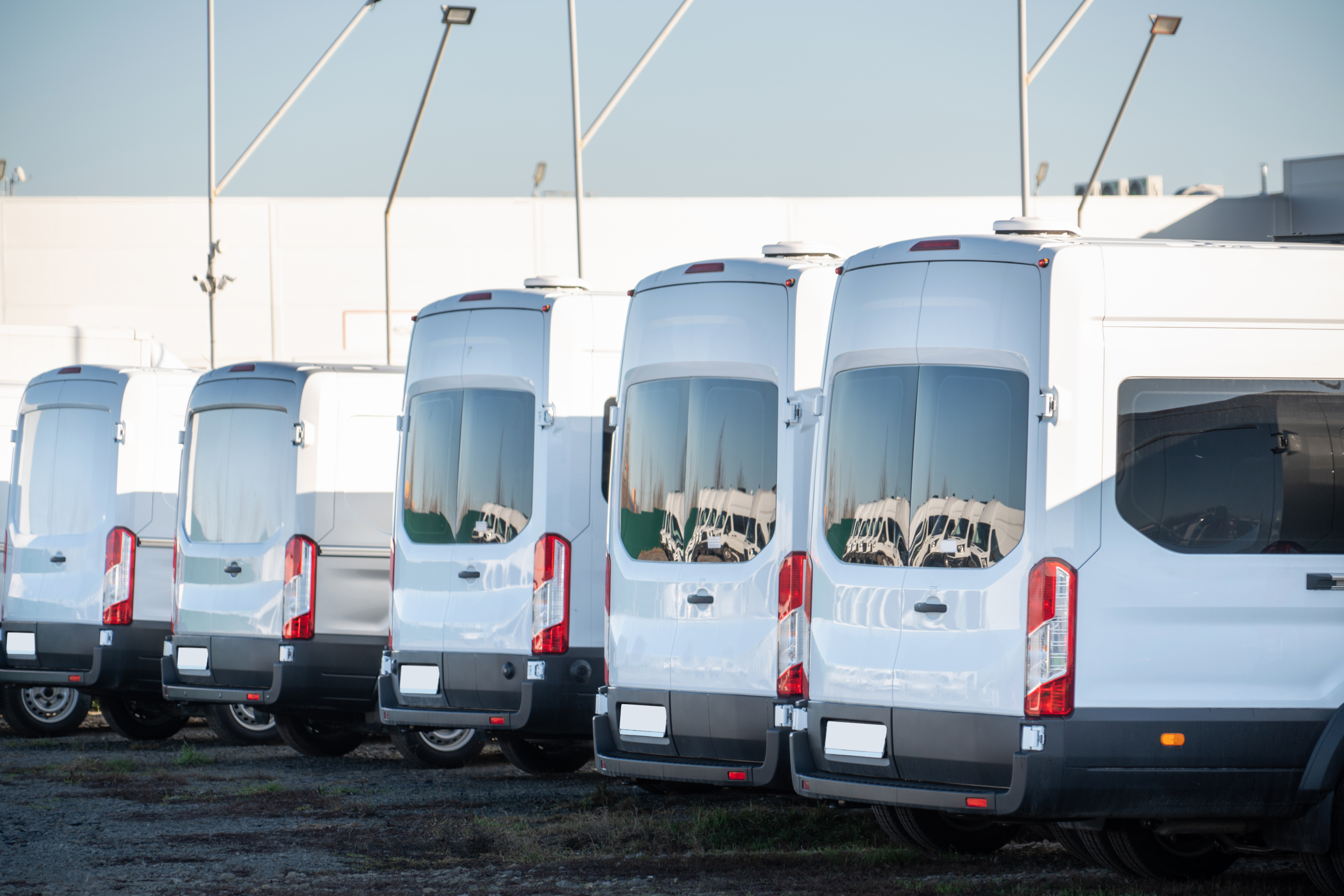 White commercial delivery vans parked together at a vehicle depot