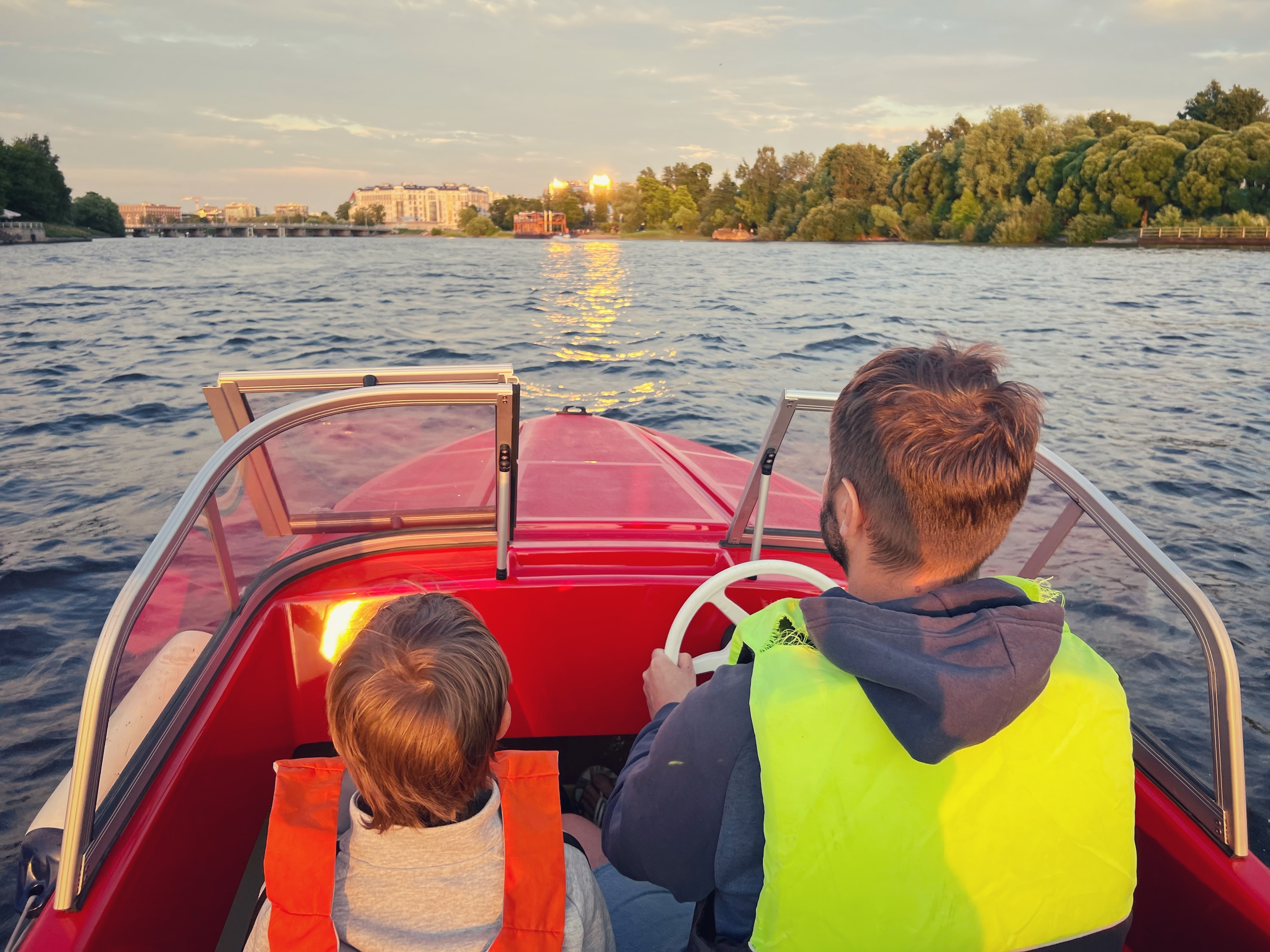 Father and son wearing life jackets while boating together