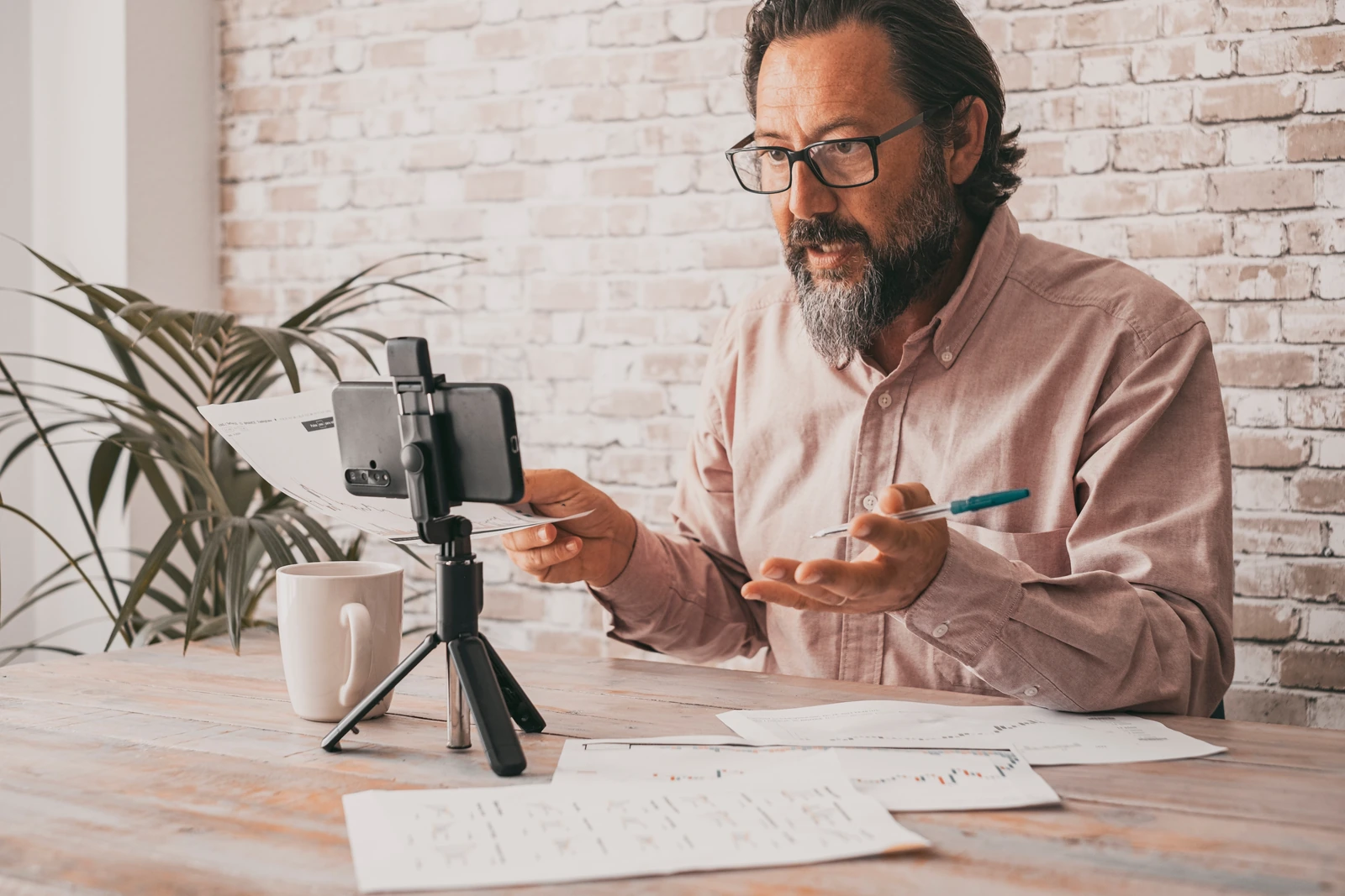 A business professional recording a personal video introduction with a smartphone.