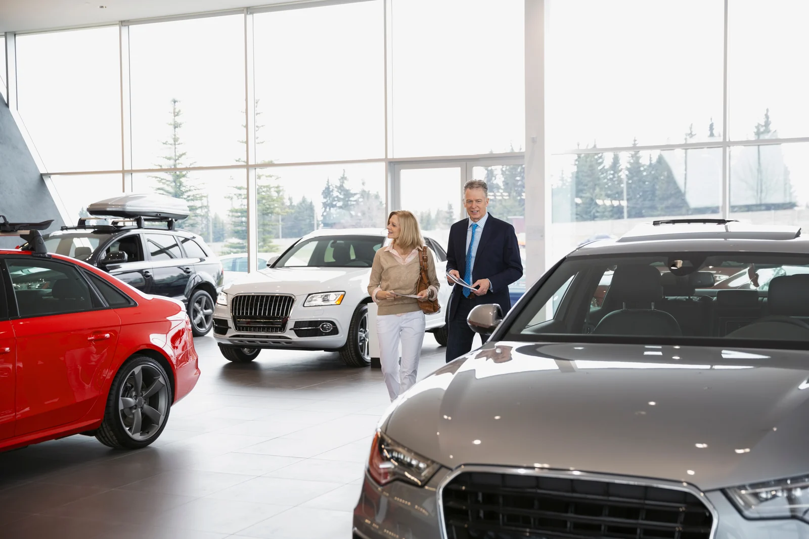 A mature couple browsing vehicles in a bright, spacious showroom.