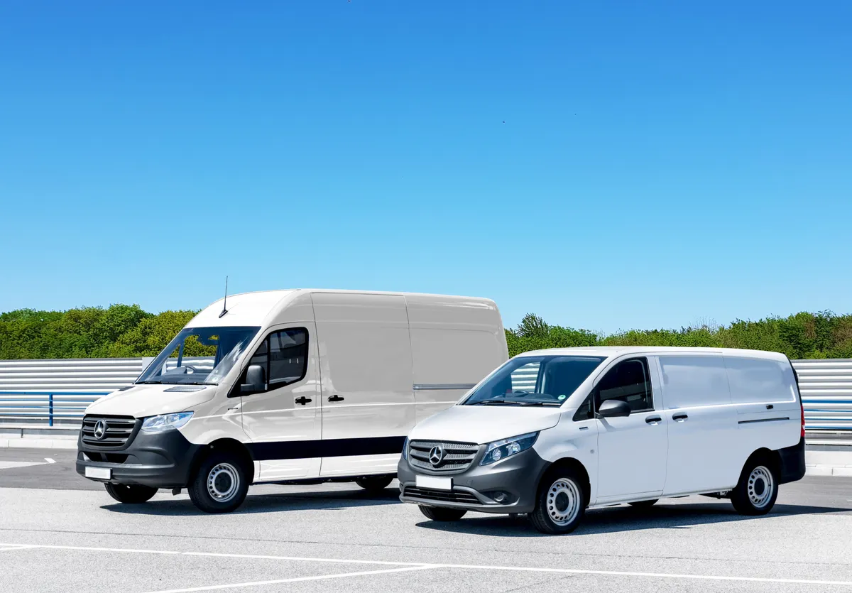 Two clean commercial delivery vans parked in bright daylight under a blue sky.