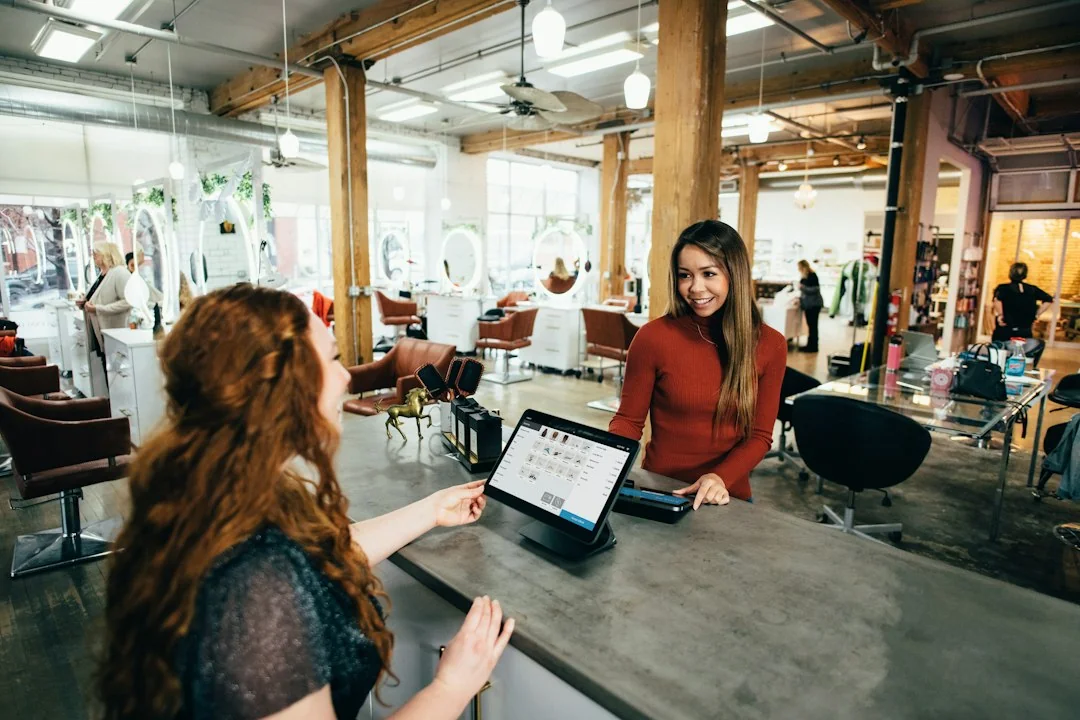 A customer speaking with a store employee at a checkout counter