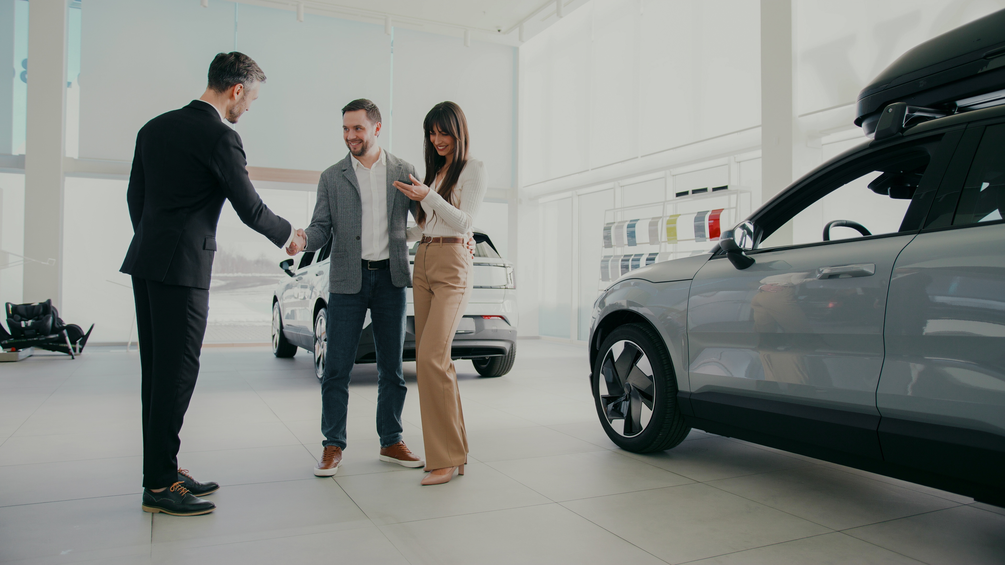 A couple receiving vehicle keys from a dealership adviser