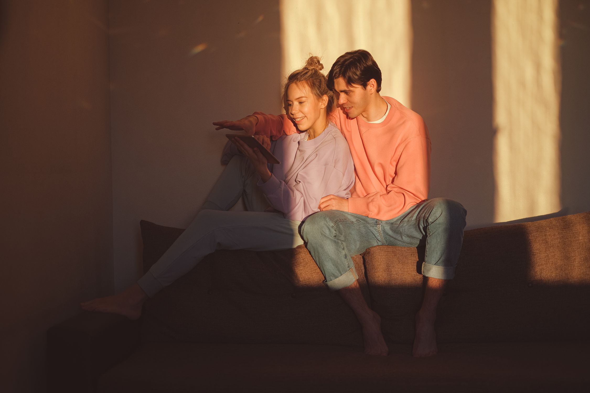 A young couple spending time together at home with a digital tablet