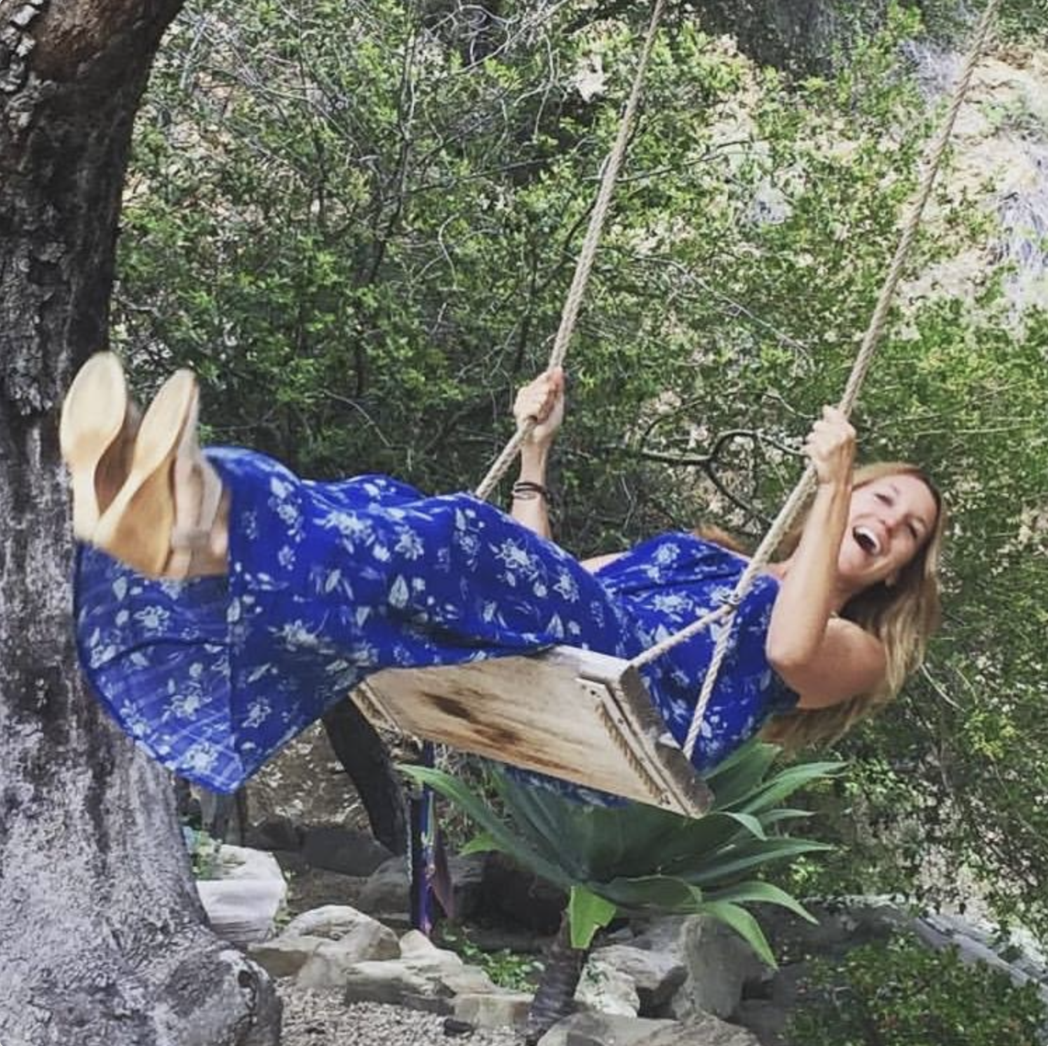Kate West laughing on a rope swing