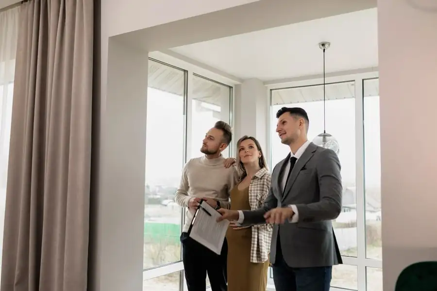 Agente inmobiliario mostrando una casa a una pareja