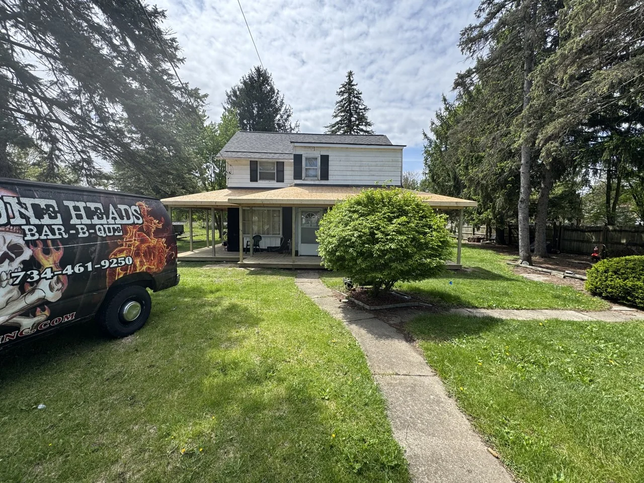 Front porch posts and roof sheathing during construction before exterior paint changes