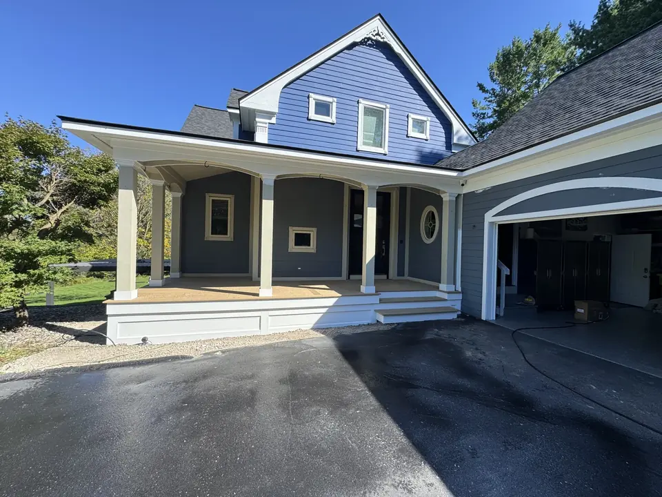 Blue home with white porch columns and a covered front entrance