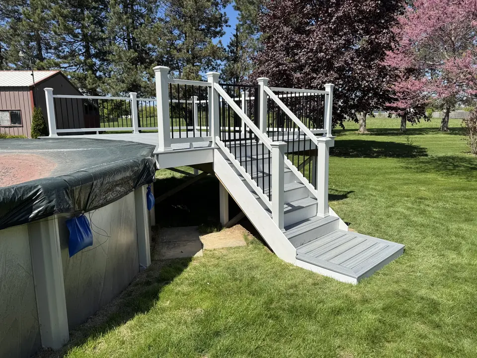 Gray pool deck and stairs with white posts and black balusters