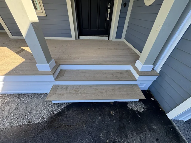 Finished broad porch steps beside a blue-sided home