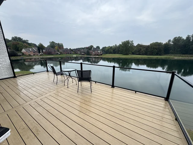 Lakeside deck with dark railings and a seating area