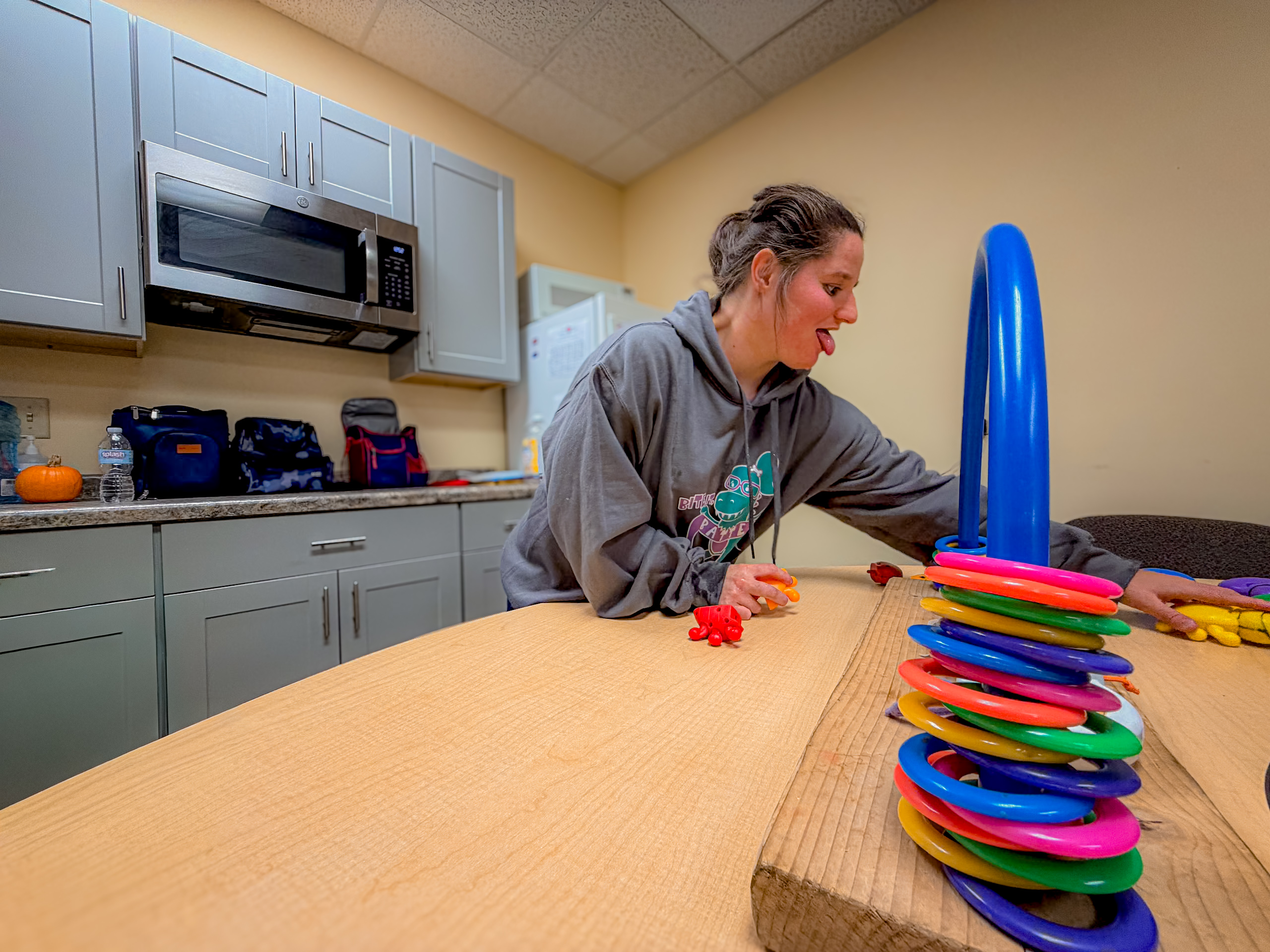 A woman at table arranging colored blocks.