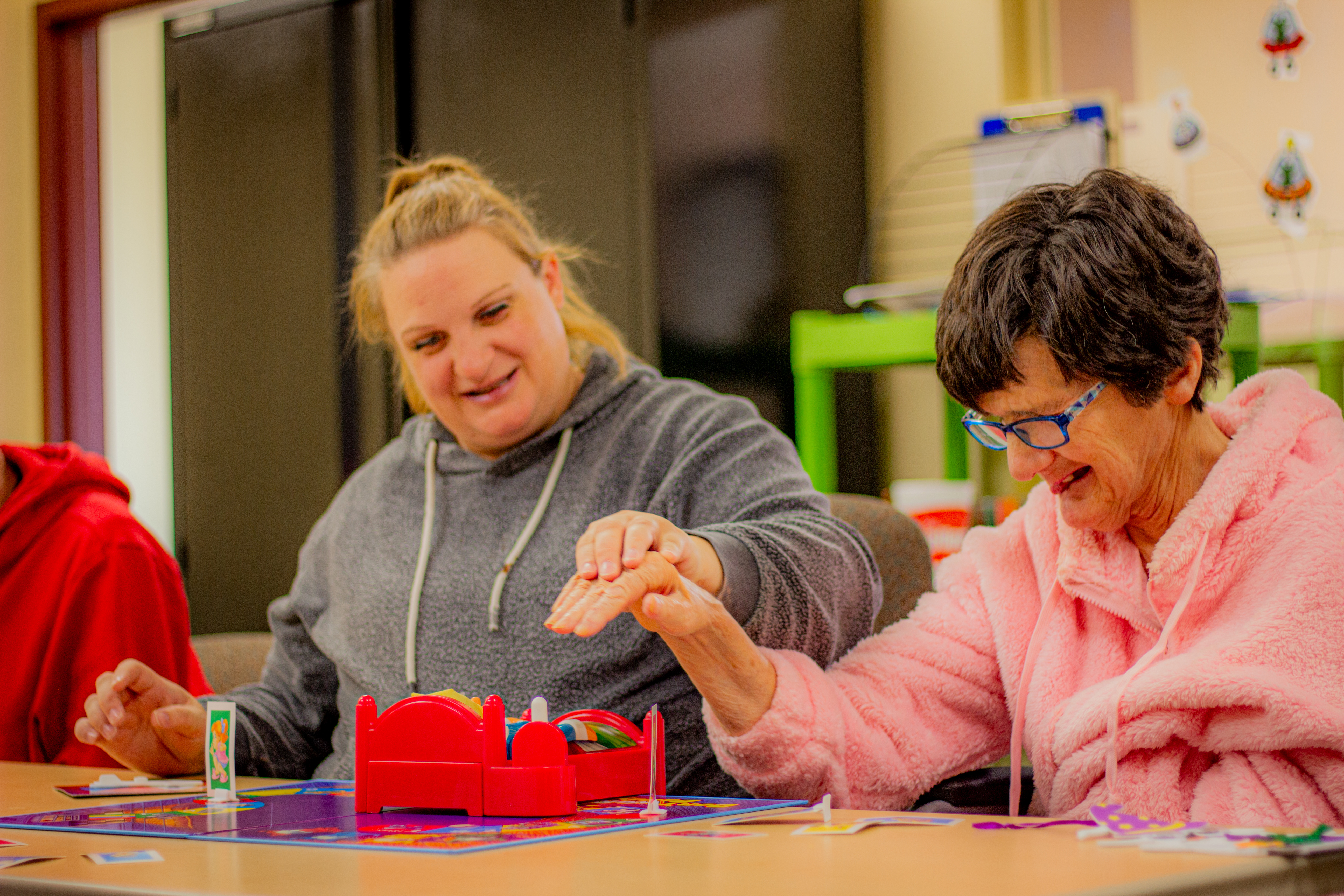 With the help of staff, a woman is playing a board game.