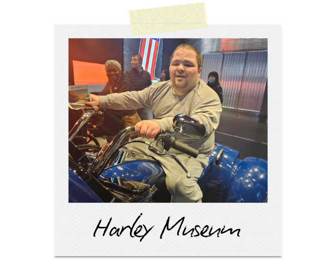 Harley Museum: A man sitting on a model motorcycle.