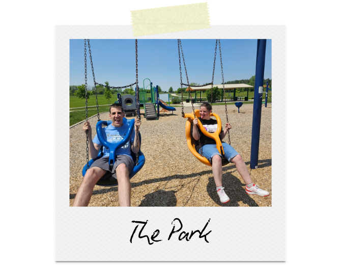The Park: Two participants sit in disability-friendly swings.