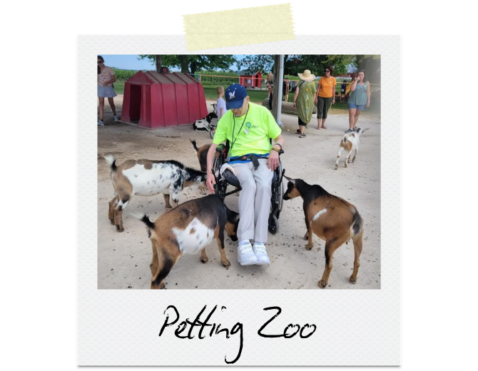 Petting Zoo: A man surrounded by goats, giving them treats and pets.