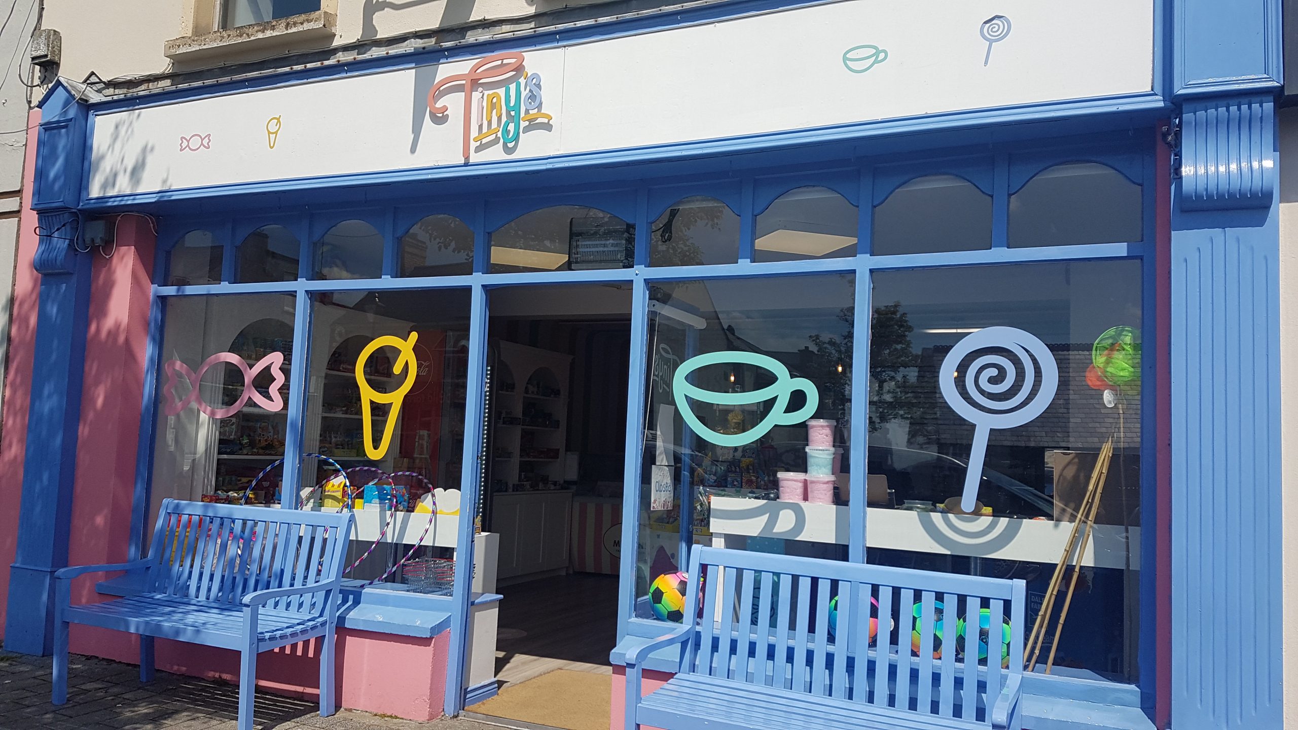 Colourful shop windows and blue benches outside Tiny's in Buncrana