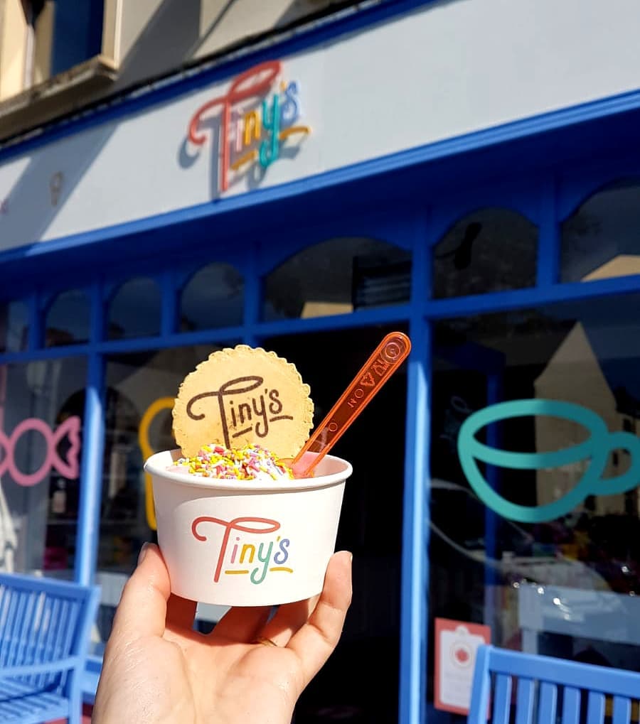 An ice cream cup with a Tiny's branded wafer outside the shop