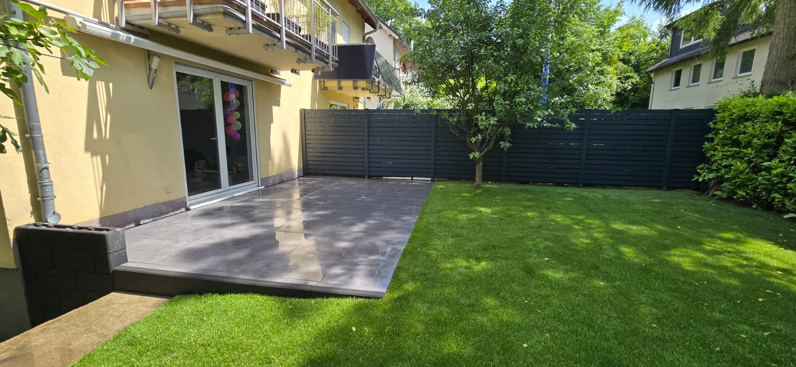 Biohort Gerätehaus auf Pflasterfläche mit gepflegtem Rasen – Gartengestaltung Castrop-Rauxel