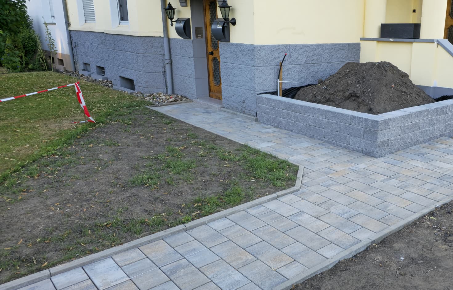 Pflasterarbeiten und Natursteinmauer beim Hauseingang in Castrop – Gartengestaltung mit Granit-Pflastersteinen