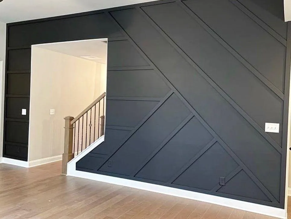 Custom 3D geometric accent wall with board and batten millwork and entertainment center built by GC Trusted Builders in Melbourne Florida featuring textured diamond pattern panels recessed lighting and modern media console