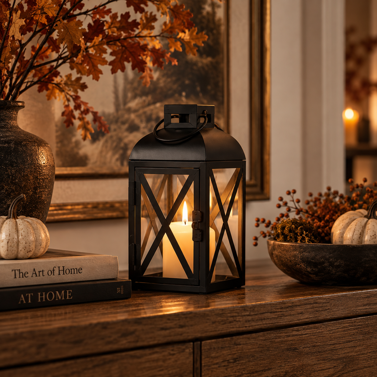 A small black metal pillar candleholder lantern beside pumpkins and foliage