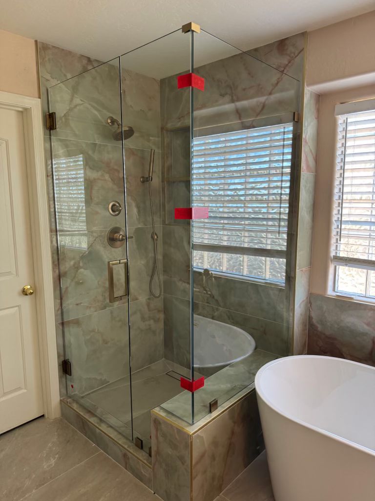 Un intérieur élégant comprenant un canapé crème, un fauteuil gris de style mid-century, une table basse en bois et quatre suspensions dorées devant un mur texturé avec des panneaux cannelés.