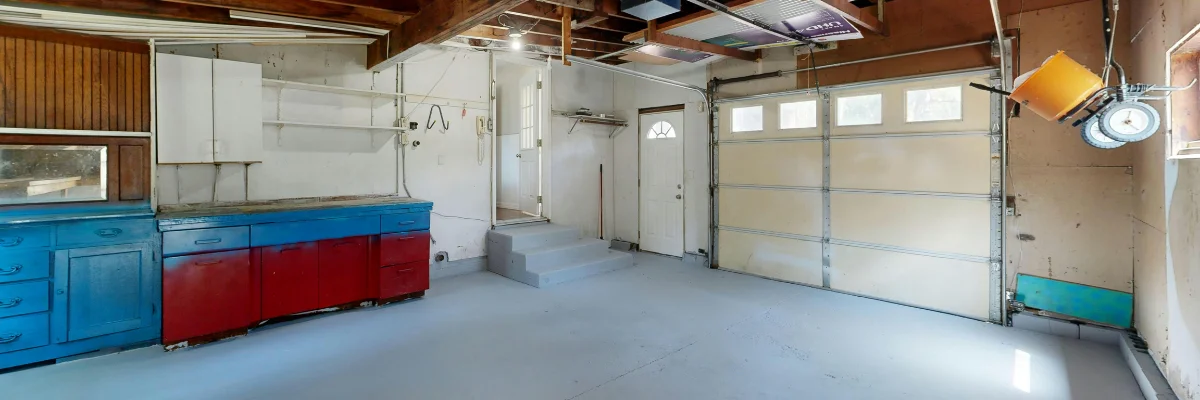 Organized garage interior with storage cabinets and workbench.