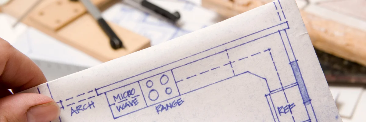 Hand holding architectural blueprint for home design project.