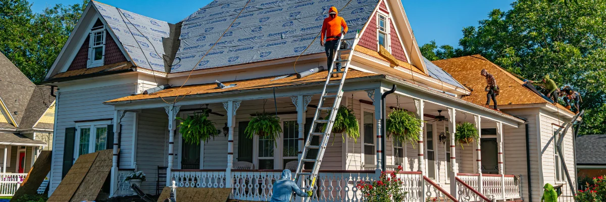 Roofing contractors installing new roof shingles on house. Roofing contractors installing new roof shingles on house.