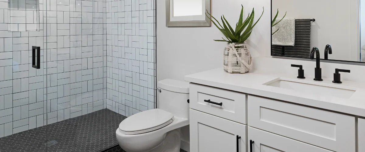 A modern bathroom interior featuring a unique oval mirror, stone sink, and elegant marble walls with accent lighting.