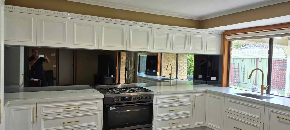 Custom mirror glass splashback reflecting light in a contemporary Melbourne home