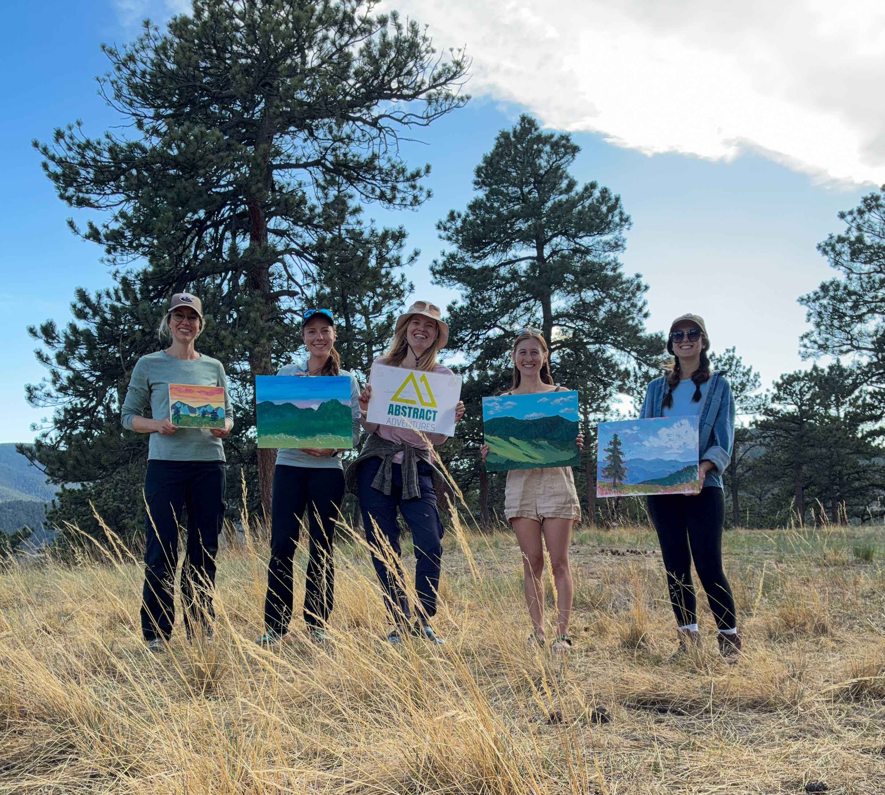 four artists holding up paintings four artists holding up paintings
